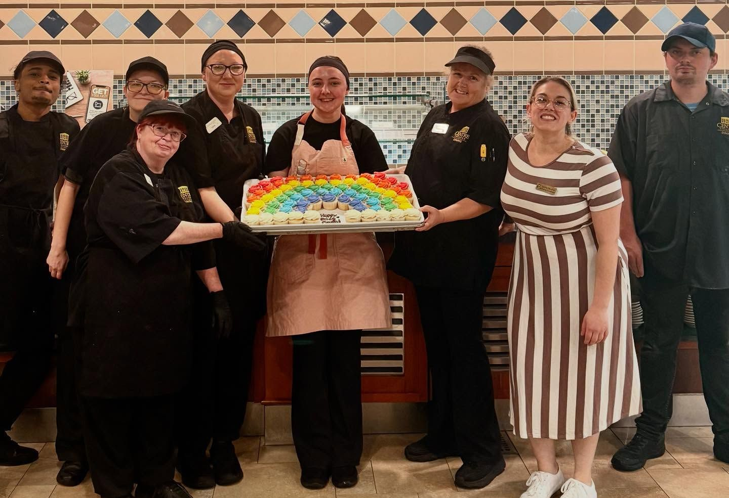 A group of chefs are posing for a picture in a kitchen.