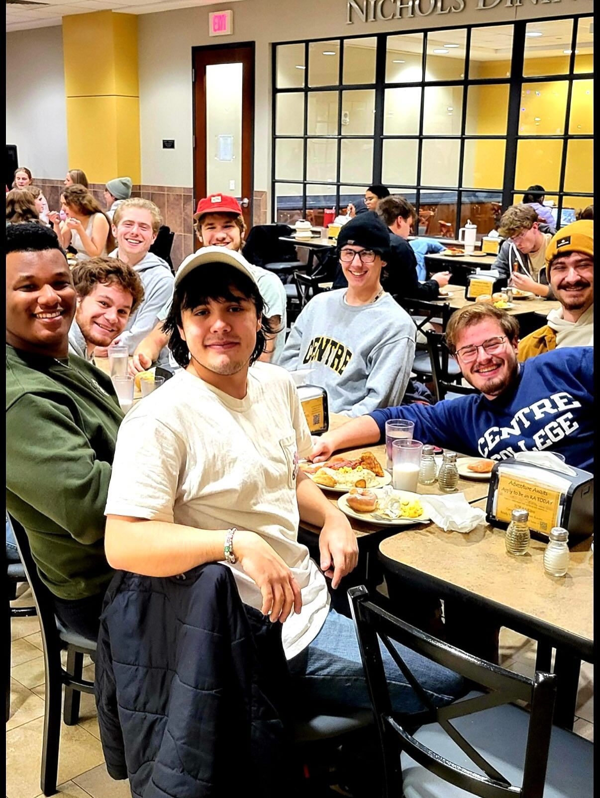 A man in a chef 's hat is posing for a picture with two other chefs