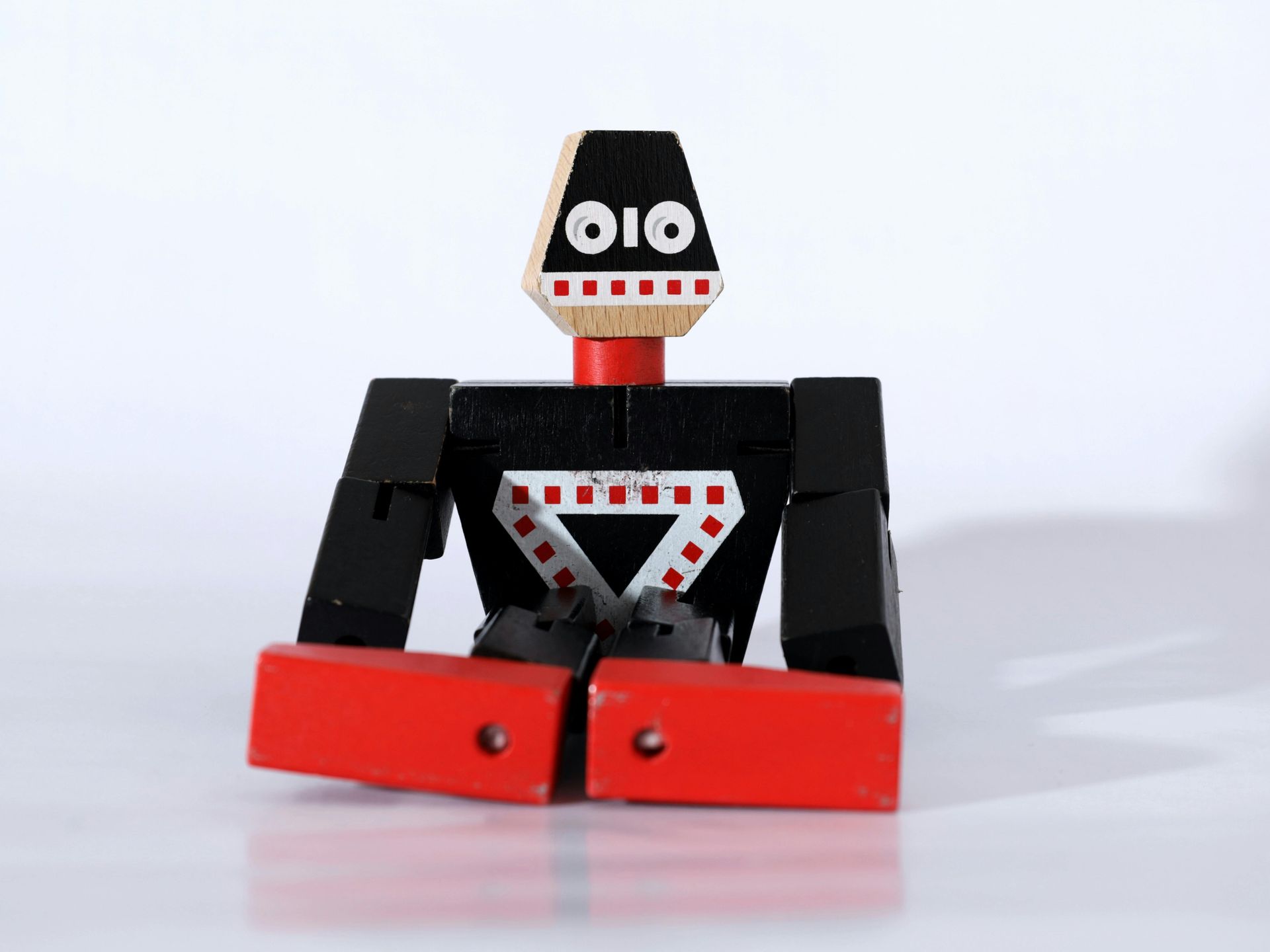 Um robô de brinquedo preto e vermelho com a palavra oio na cabeça