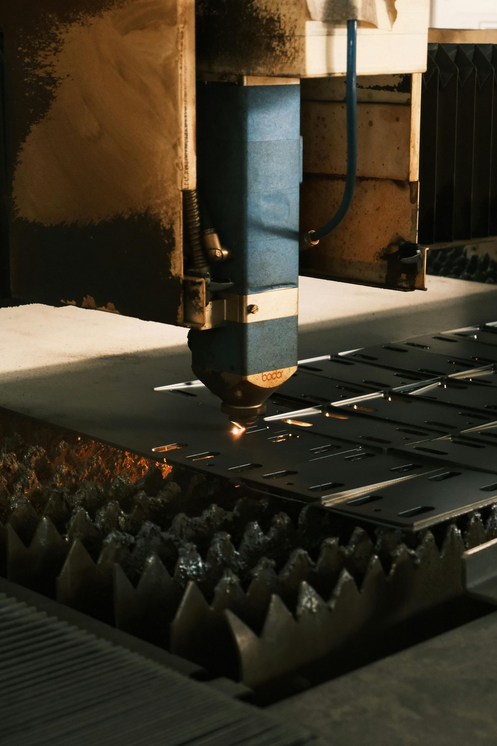 Uma máquina está cortando um pedaço de metal em uma fábrica.