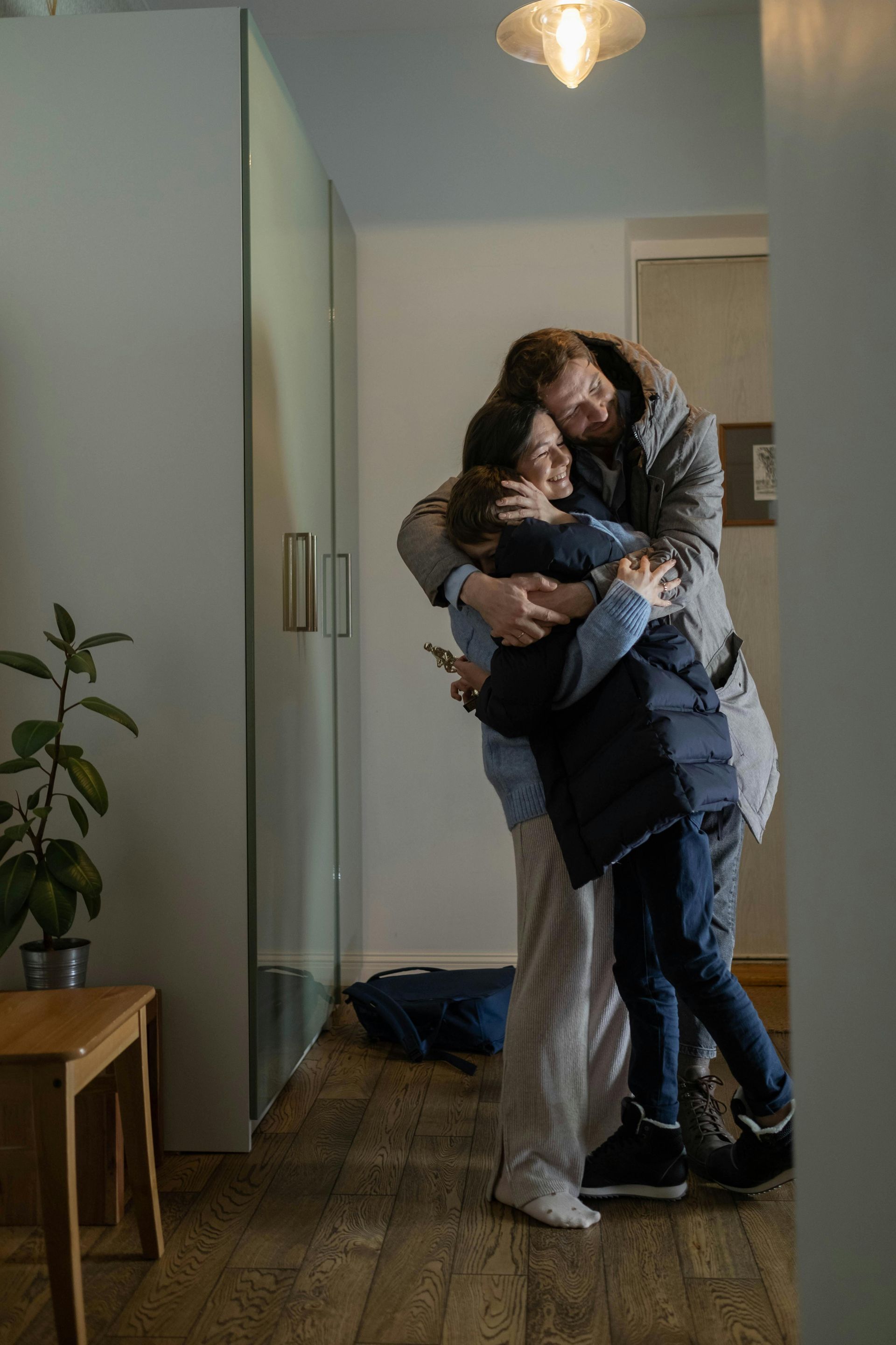 Uma família está se abraçando em um corredor.