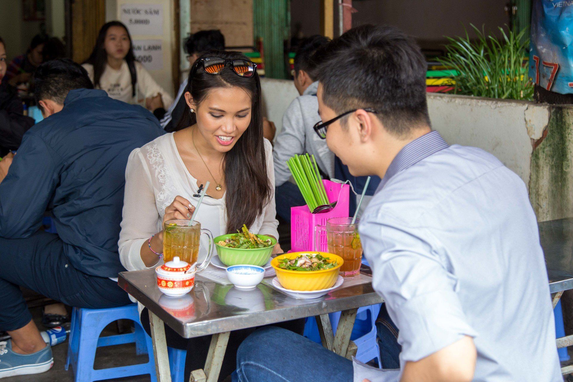 A man and a woman are sitting at a table eating food.