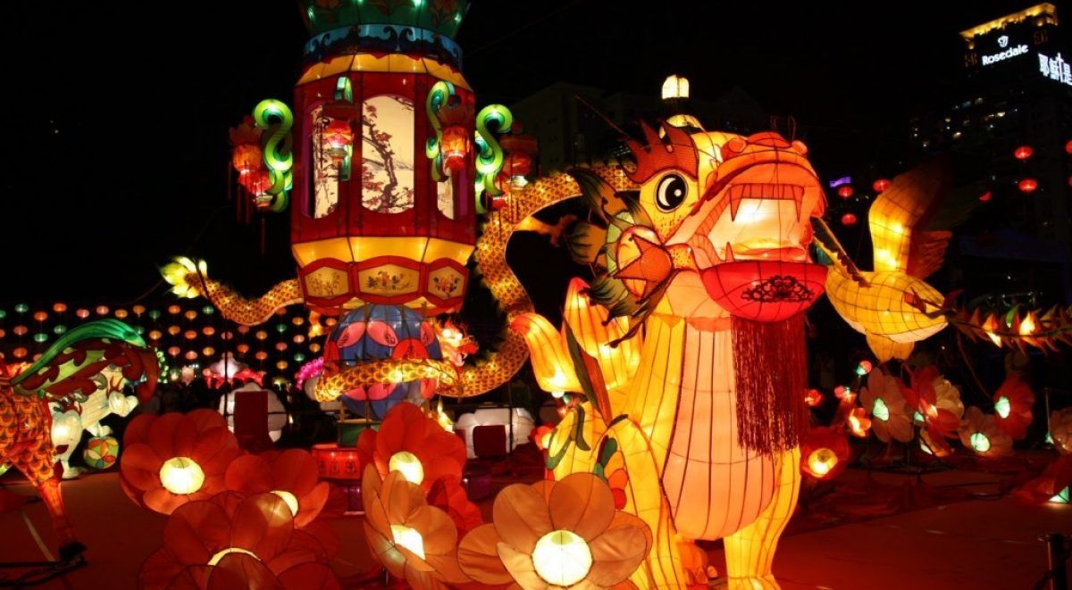 A bunch of lanterns are lit up at night in a park.