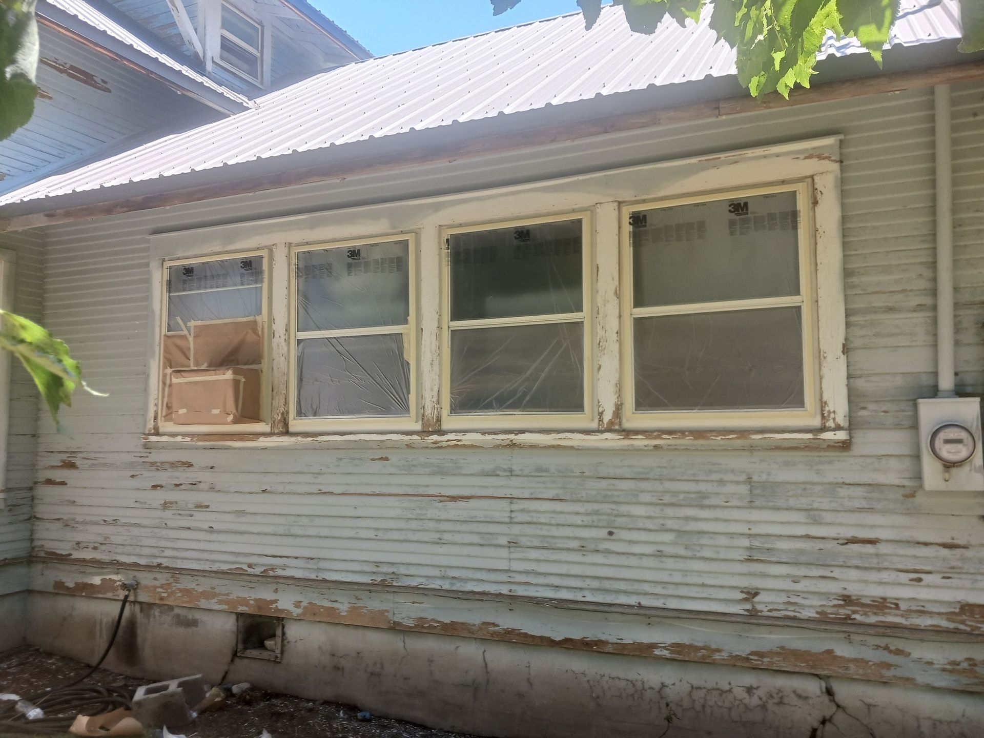 A white house with a white roof and a few windows