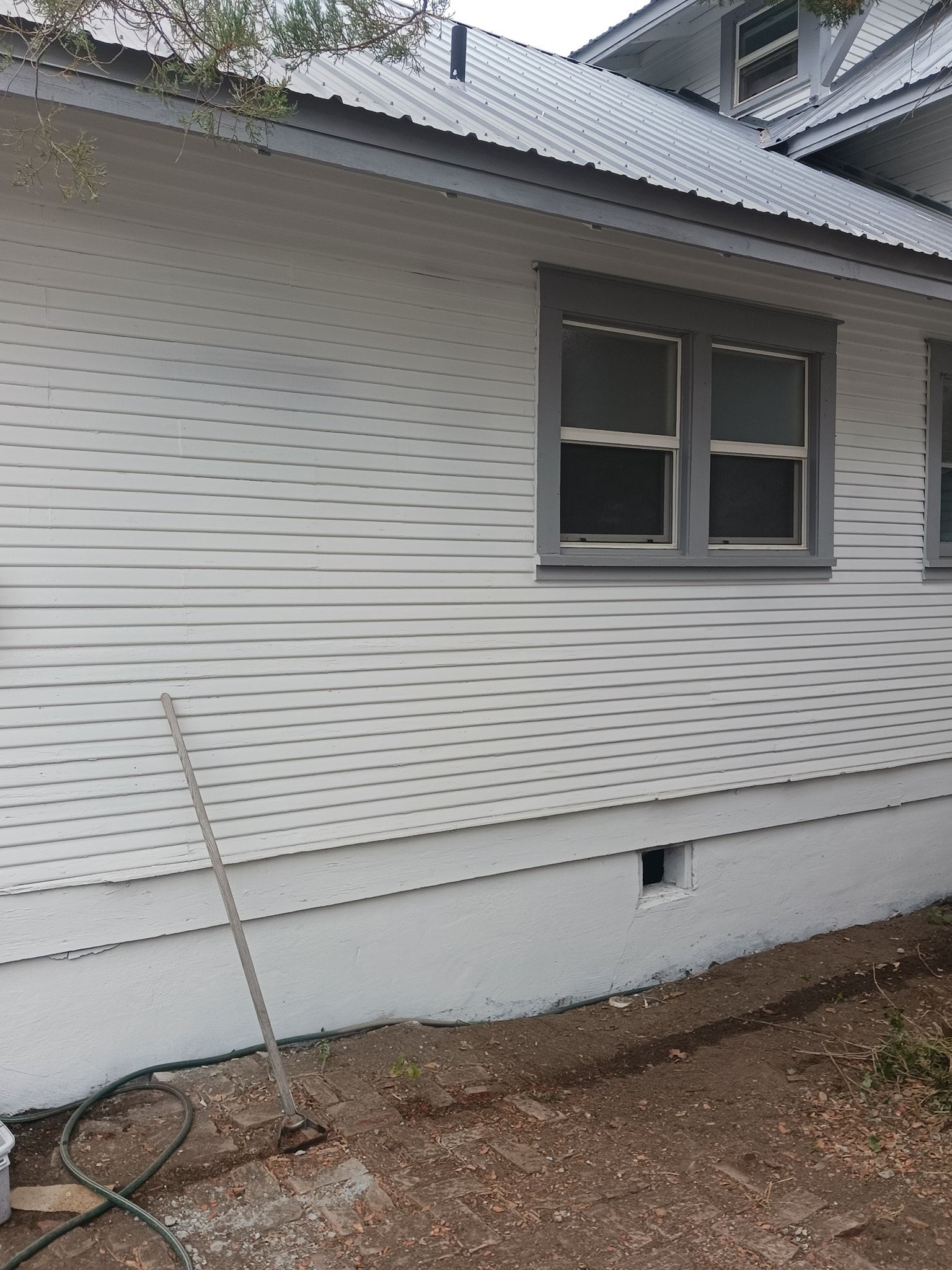 A white house with a gray roof and two windows