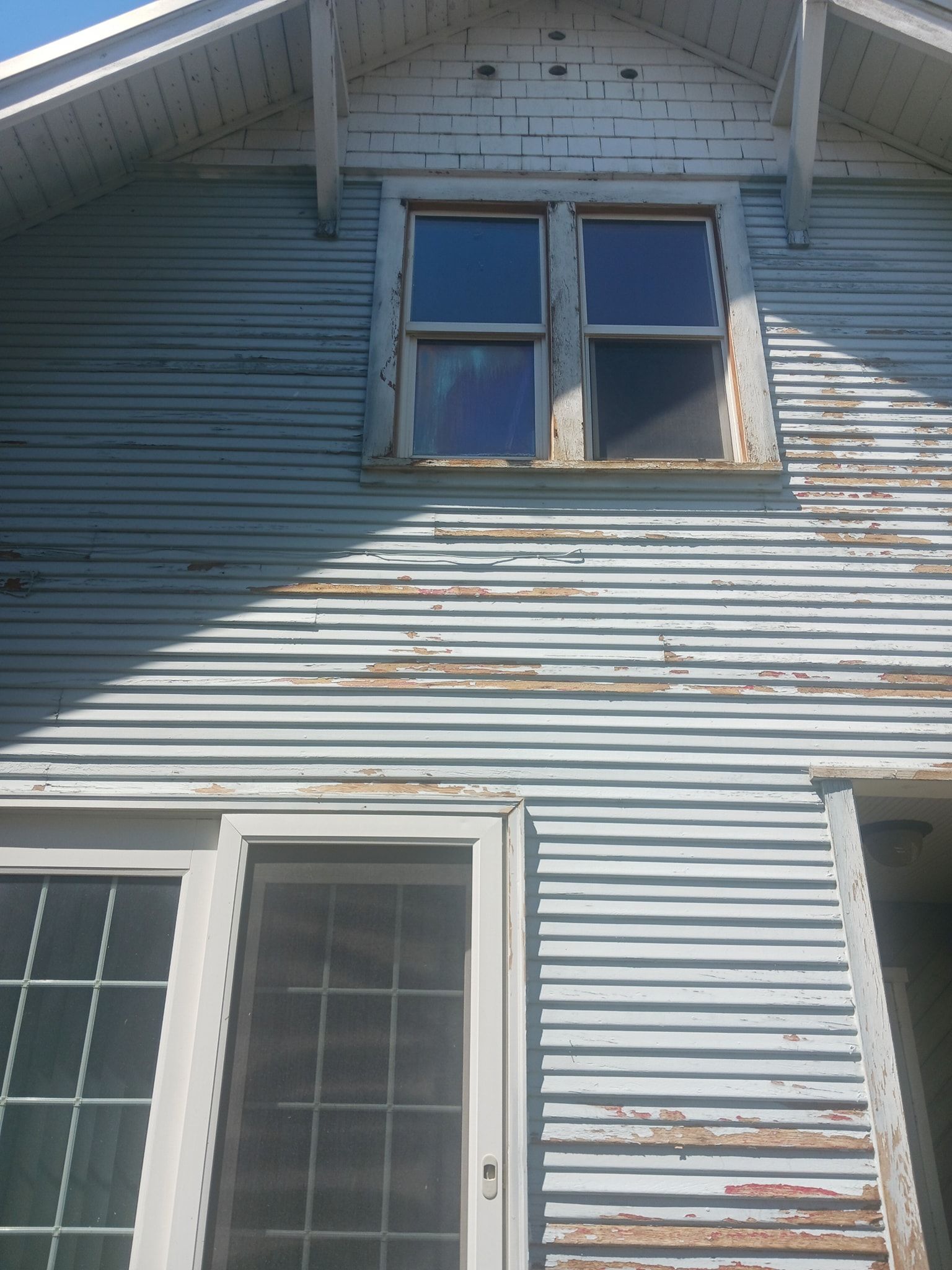 A house with a blue siding and white windows