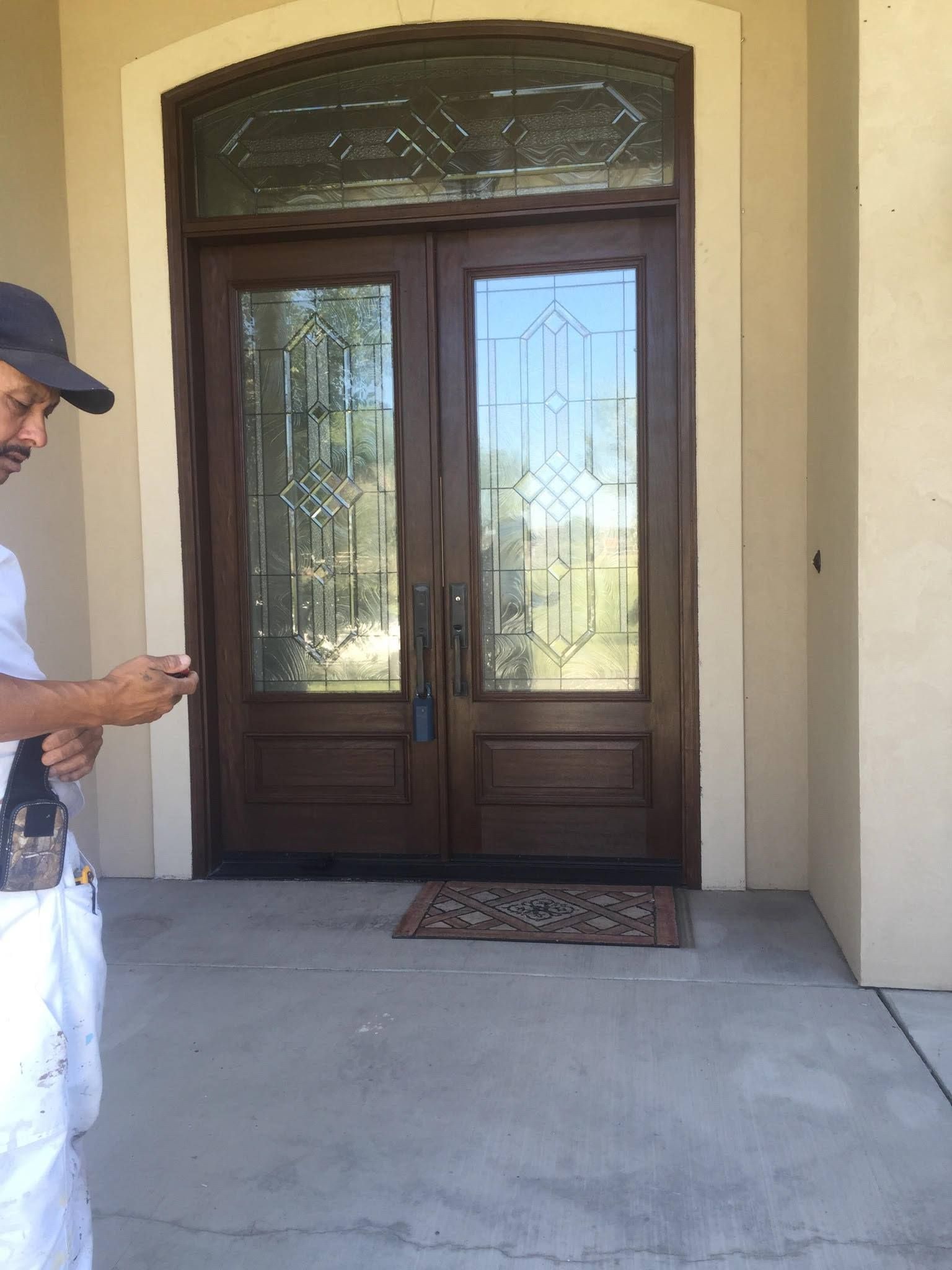 A man is standing in front of a large wooden door.