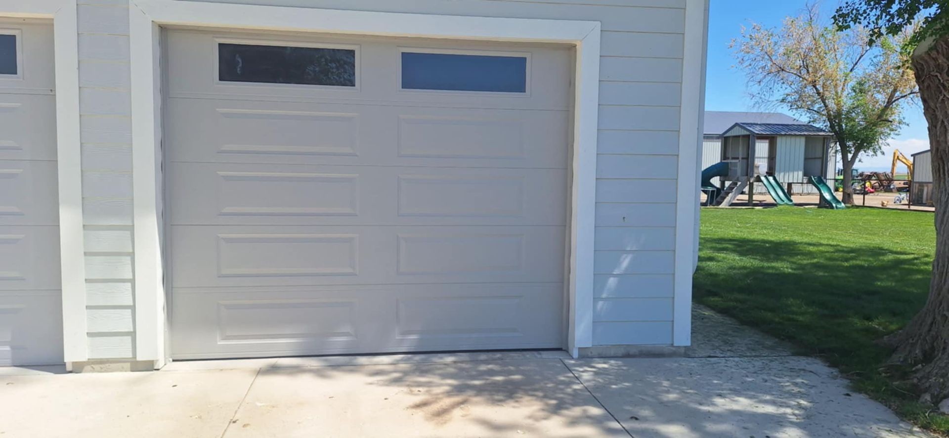 A garage door is open in front of a house.