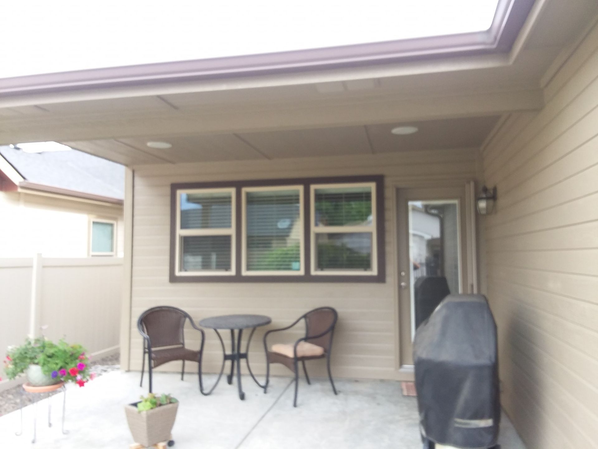 A patio with a table and chairs and a grill
