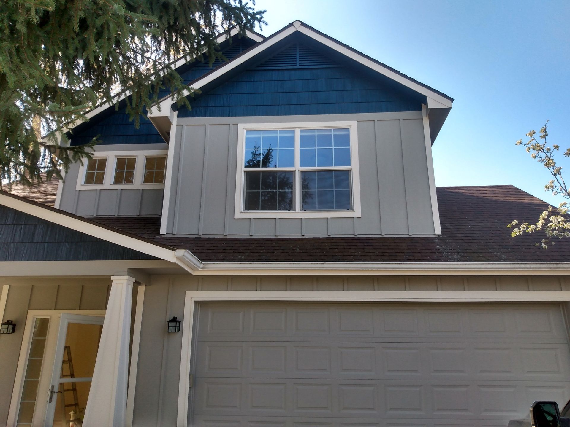 A house with a blue roof and a large window.