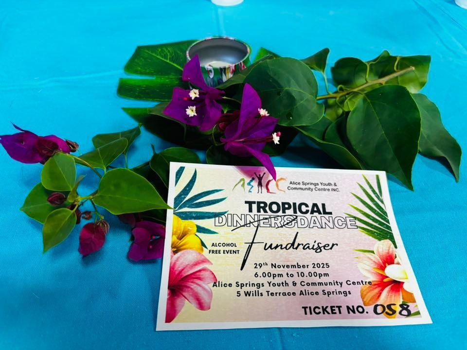 Tropical dinner fundraiser ticket with floral decorations on blue cloth.