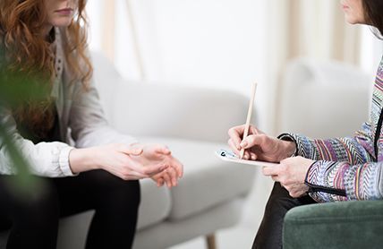 A Woman Is Sitting On A Couch Talking To A Therapist — Angels for Pets In Capricorn Coast, QLD