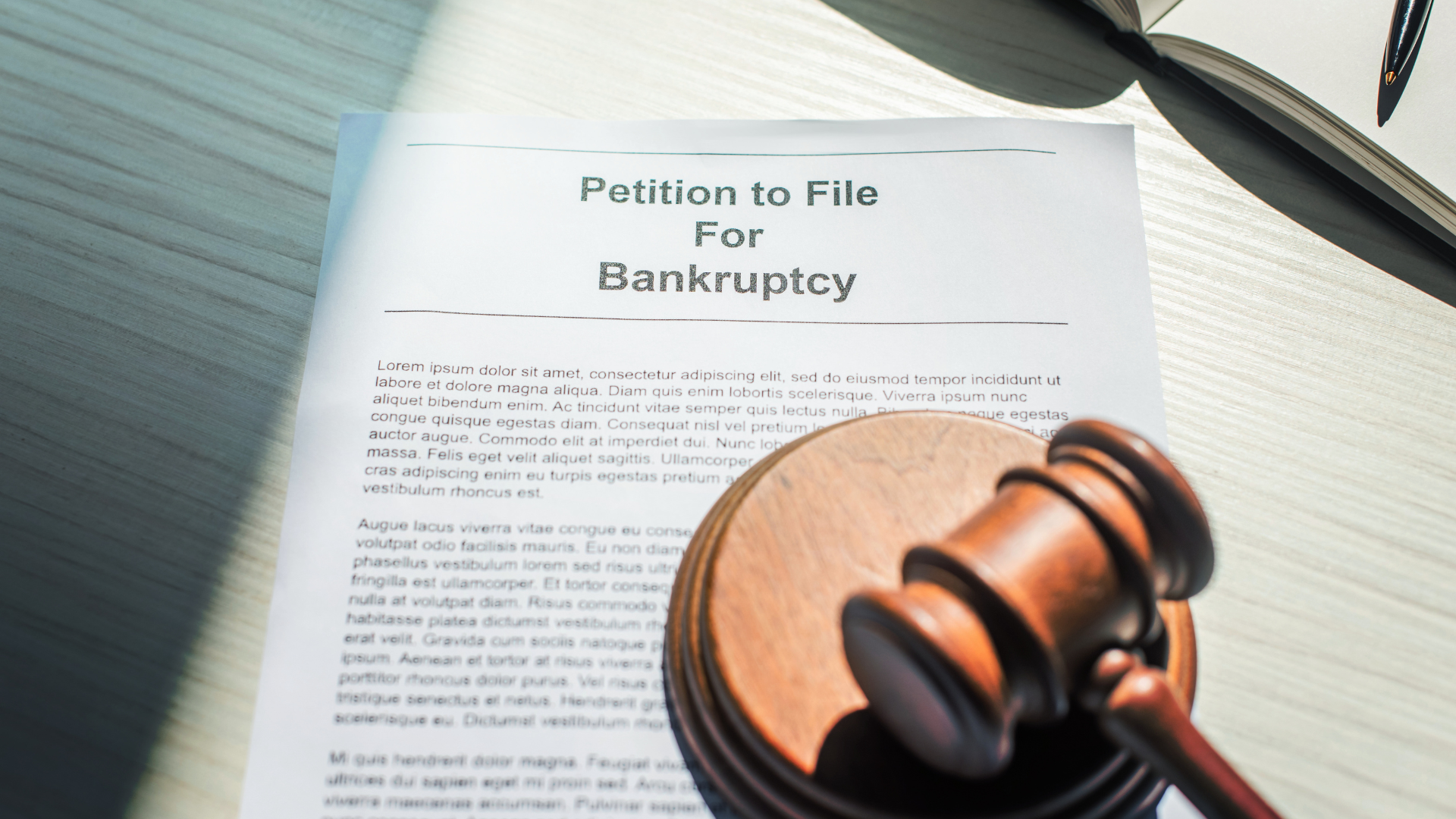 A judge 's gavel is sitting on top of a petition to file for bankruptcy.