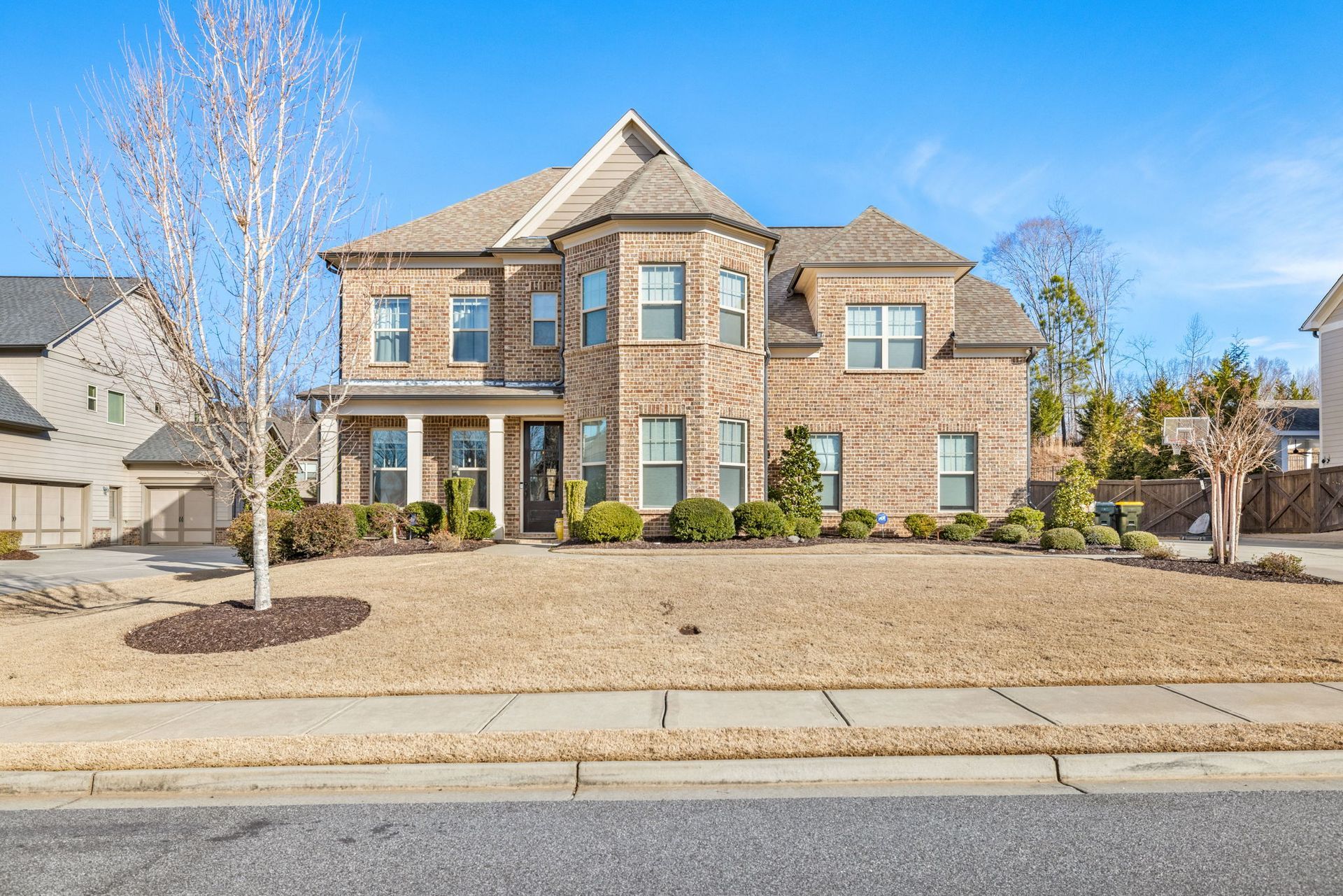 A large house with a slate roof and two garages