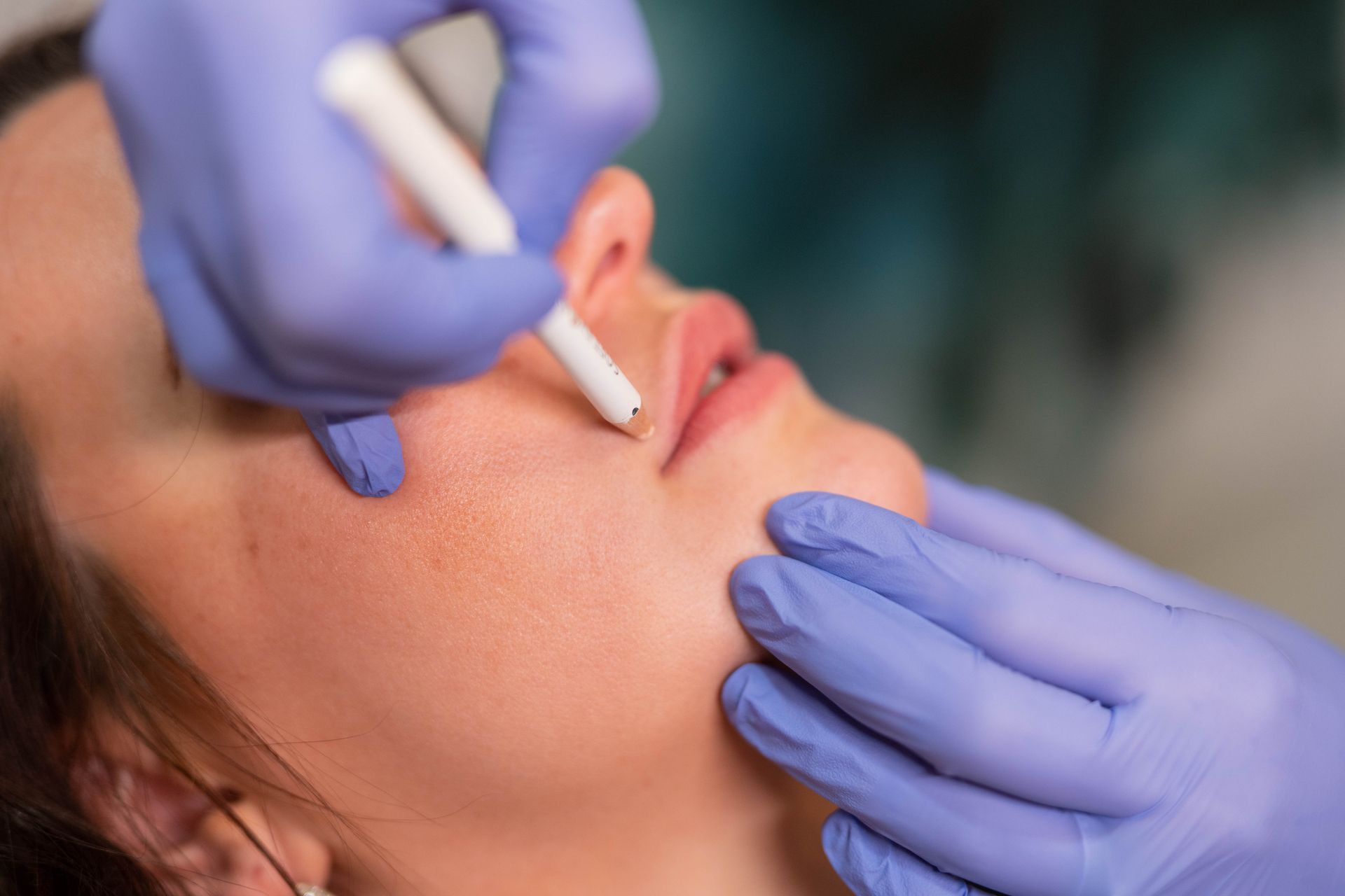 A woman is getting a needle in her nose.