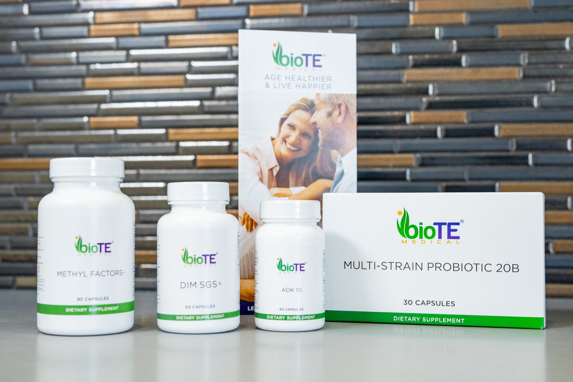 Three bottles of biote products are sitting on a table in front of a tiled wall.
