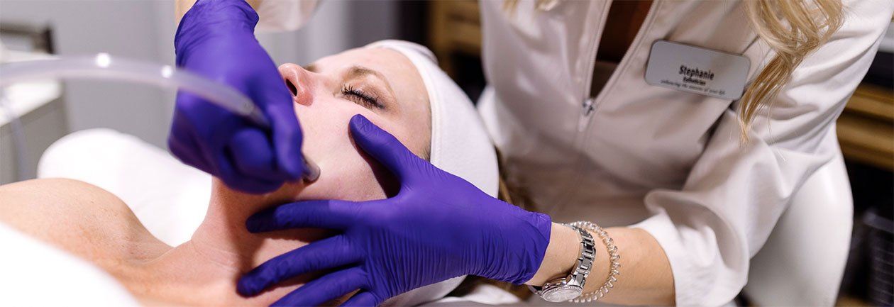 A woman is getting a facial treatment at a beauty salon.