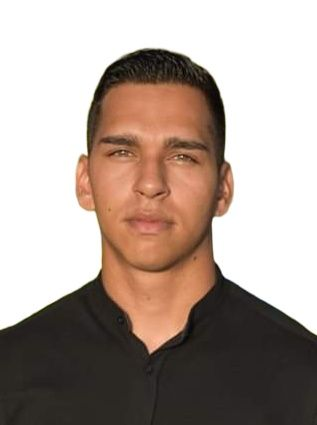 Man in het zwarte shirt kijkt recht in de camera met een neutrale uitdrukking.