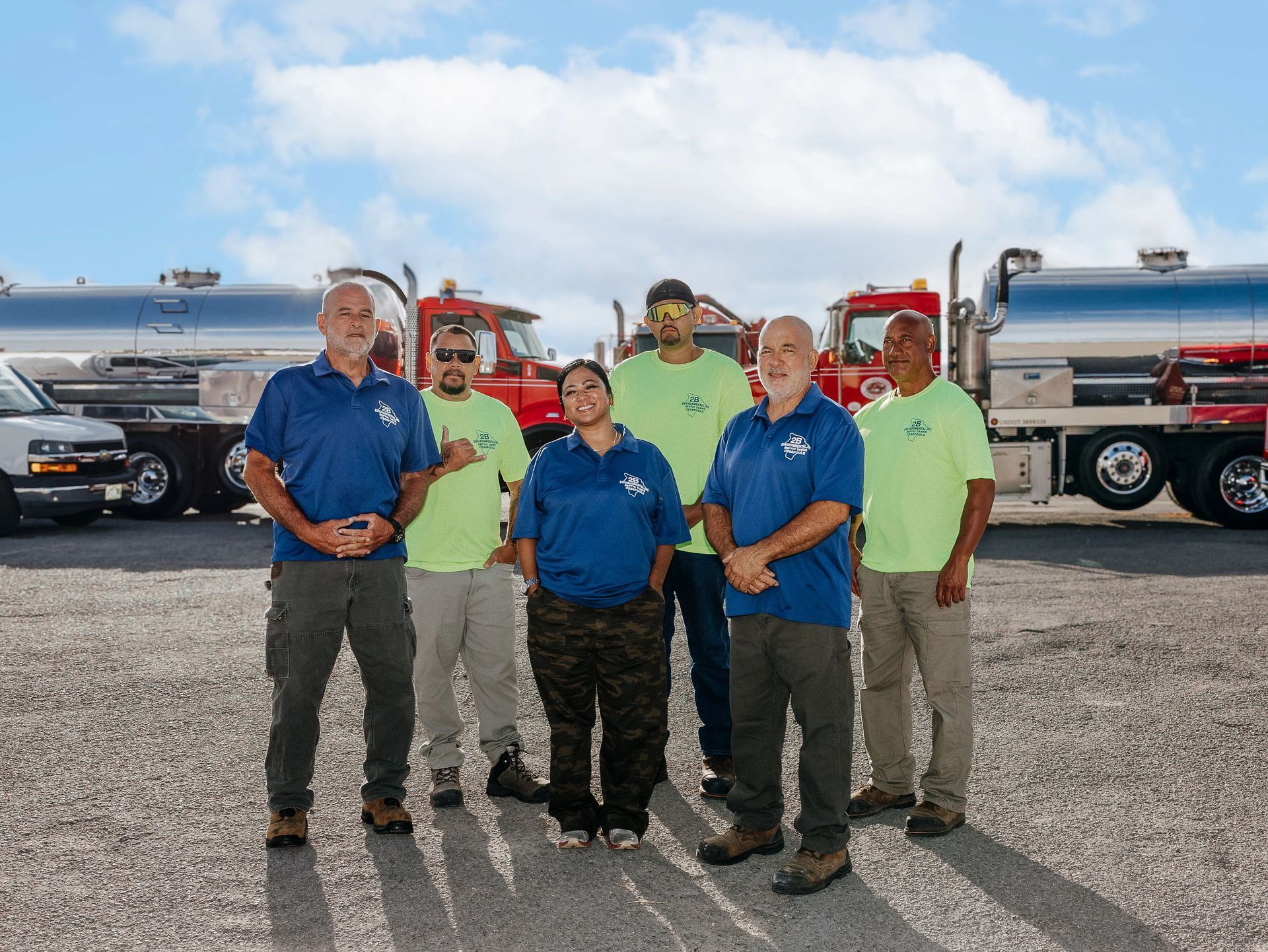 Smiling team members in uniform in front of a branded service vehicle.