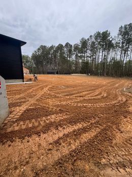 A bulldozer is sitting in the middle of a dirt field.