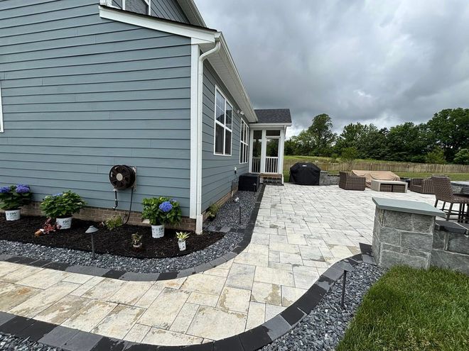 A house with a patio and a walkway in front of it.