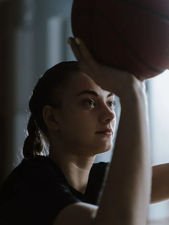a prep school women athlete holding a basketball in her hand