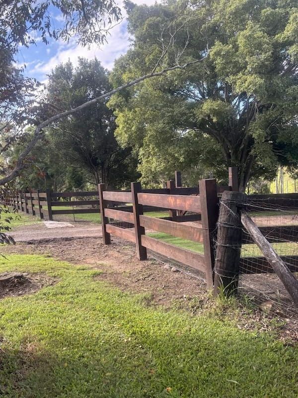 Wooden Fence Bordering a Grassy Area With Trees in the Background — Keith Dellit Rural Fencing in Yandina Creek, QLD
