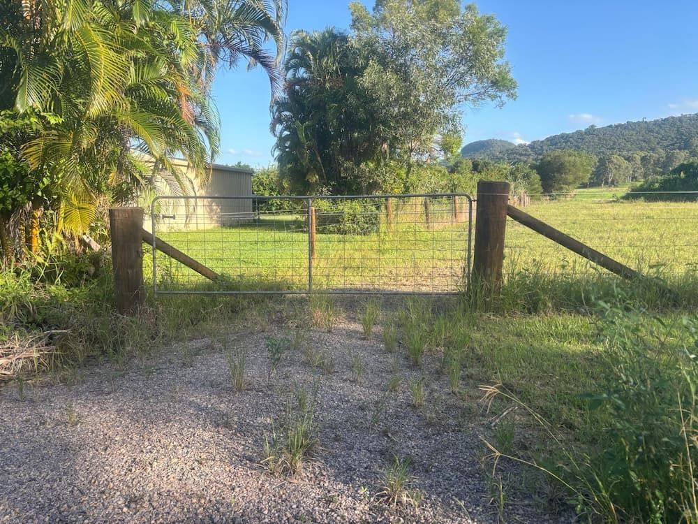 Open Gate on a Gravel Path Leading to a Grassy Field — Keith Dellit Rural Fencing in Yandina Creek, QLD 