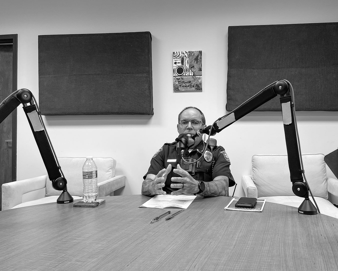 A man is sitting at a table talking into a microphone