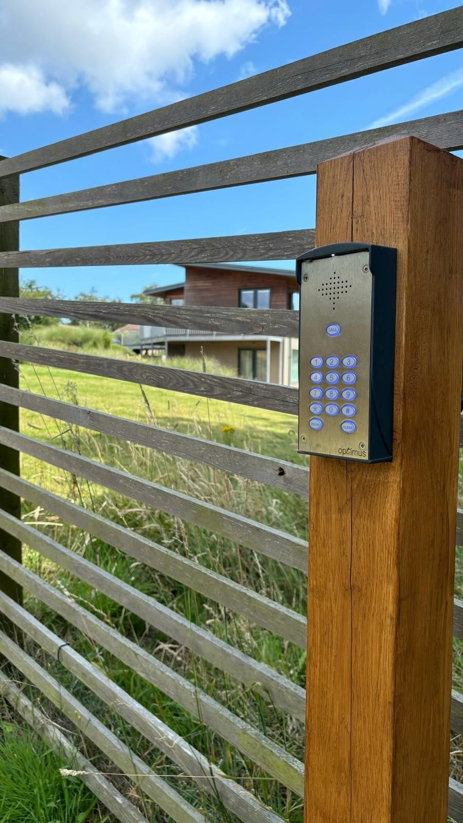 A wooden gate is sitting on top of a brick driveway.