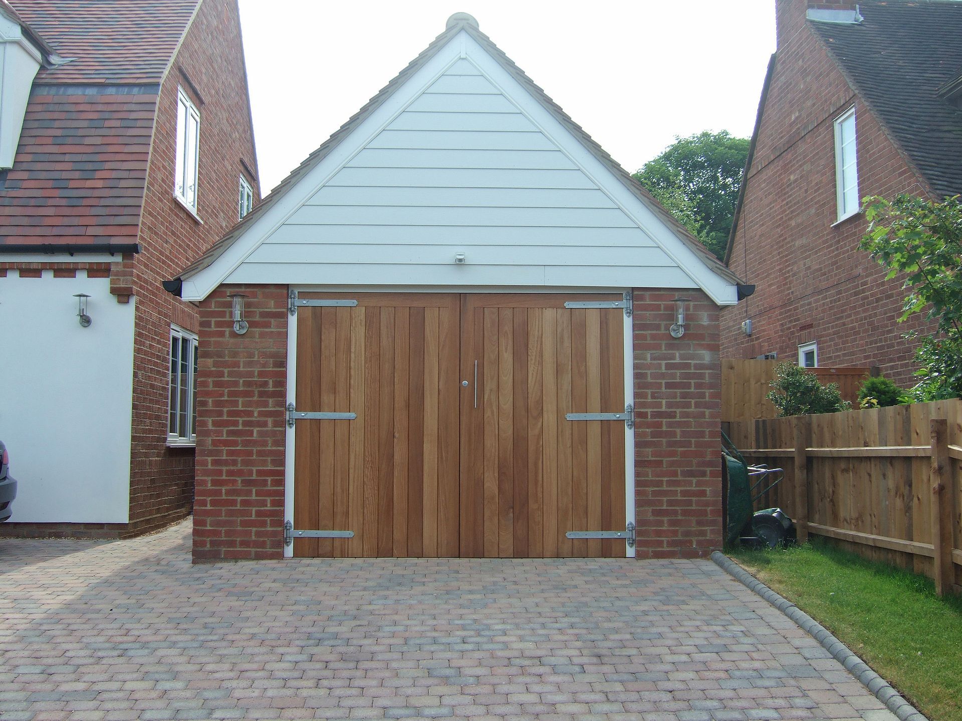 A garage with a wooden door and a black roof