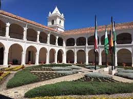 Un gran edificio blanco con arcos y banderas frente a él.