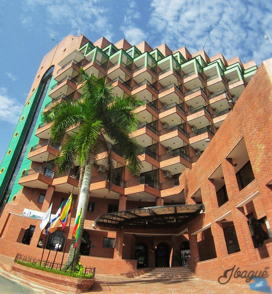 Un gran edificio de ladrillo con una palmera frente a él