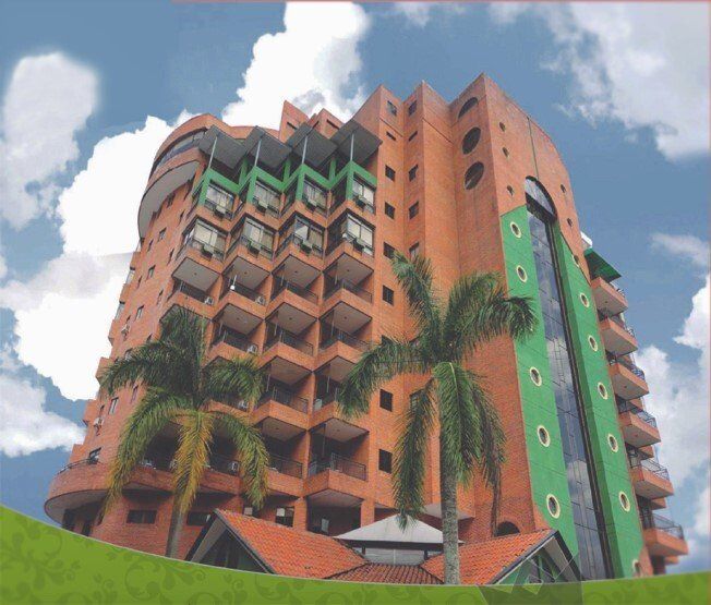 Un edificio alto de ladrillo con palmeras frente a él