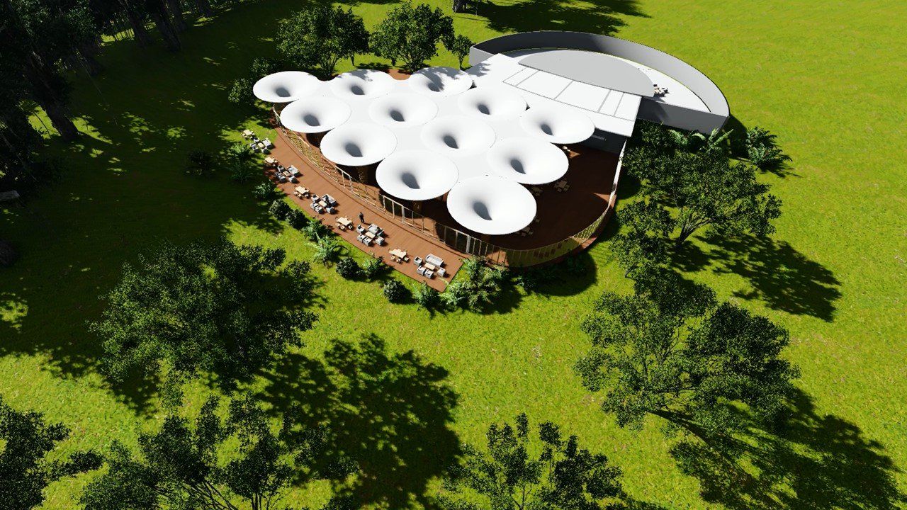 Una vista aérea de un edificio en medio de un campo rodeado de árboles.