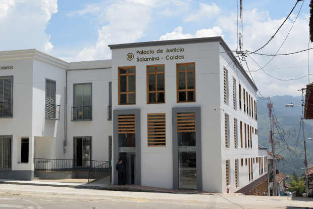 Un edificio blanco con un cartel que dice palacio de justicia