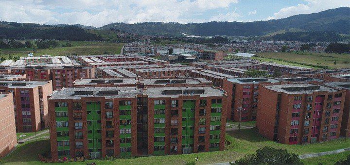 Una vista aérea de una zona residencial con muchos edificios y montañas al fondo.