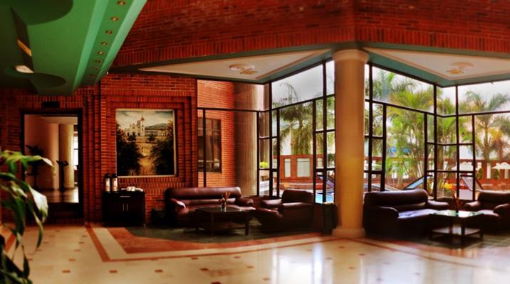 El vestíbulo de un hotel con muchas ventanas y muebles.