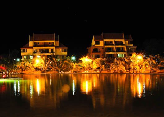 Los edificios se iluminan por la noche y se reflejan en el agua.