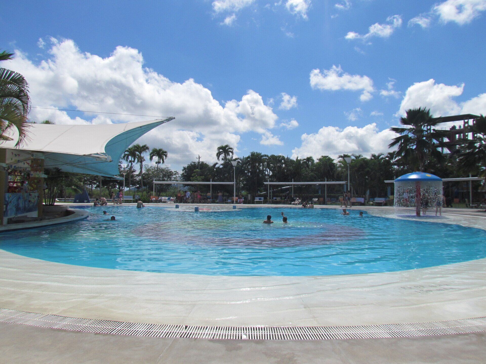 Una gran piscina con gente nadando en ella