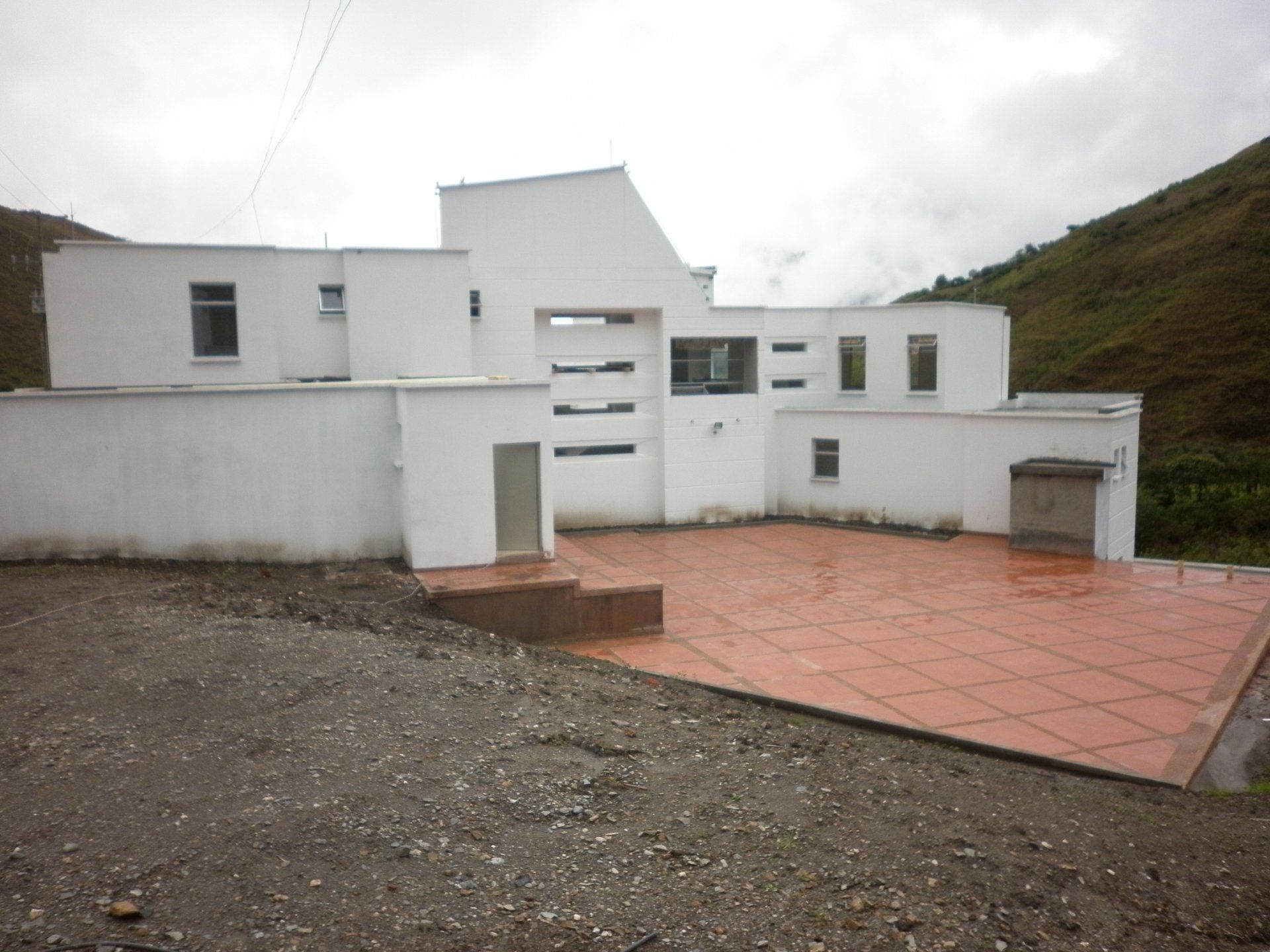 Un gran edificio blanco con un patio de ladrillos frente a él