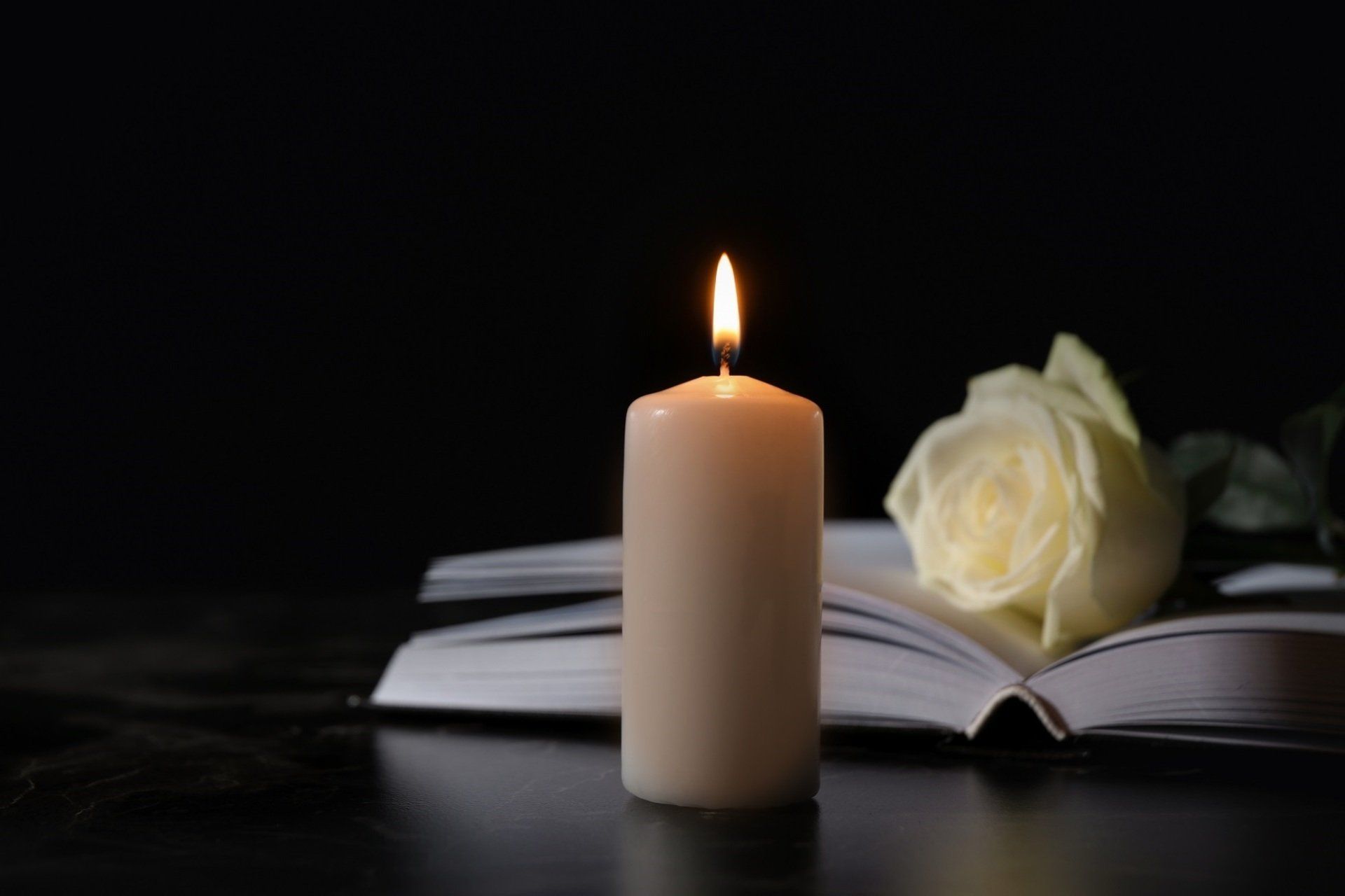 candela e rosa bianca per funerale religioso