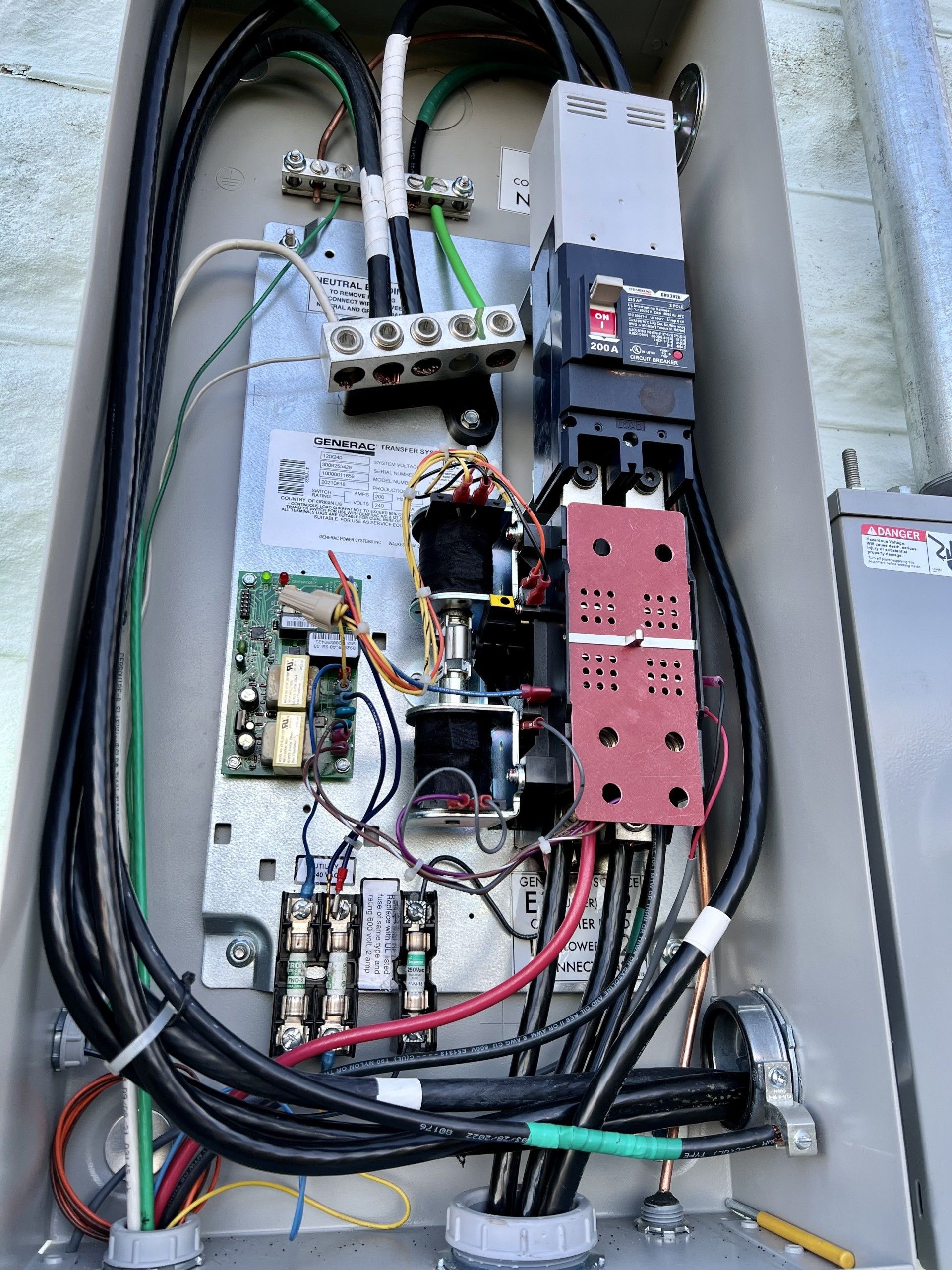 Open electrical panel with wires, circuit breakers, and components.