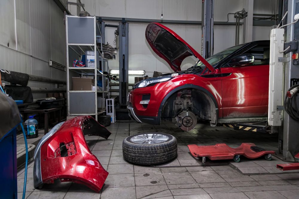 A Red Car is Parked in a Garage With Its Hood Open — Turbo's Tyres Pty Ltd In Palmerston, NT