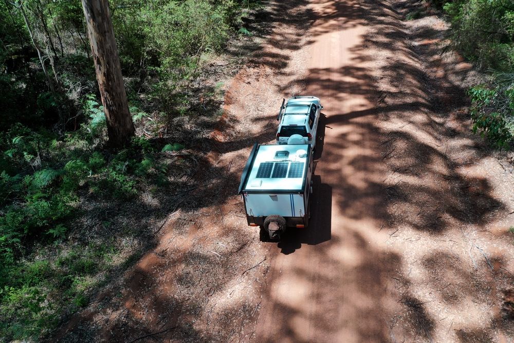 An Aerial View of a Truck Pulling a Trailer Down a Dirt Road — Turbo's Tyres Pty Ltd In Humpty Doo, NT