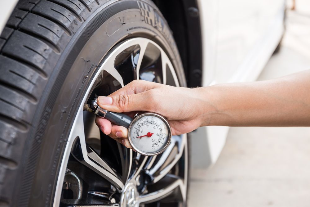 A Person is Checking the Pressure of a Tire With a Gauge — Turbo's Tyres Pty Ltd In Palmerston, NT