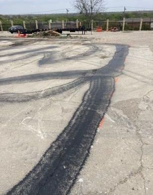 Road construction workers laying fresh asphalt for a new road.