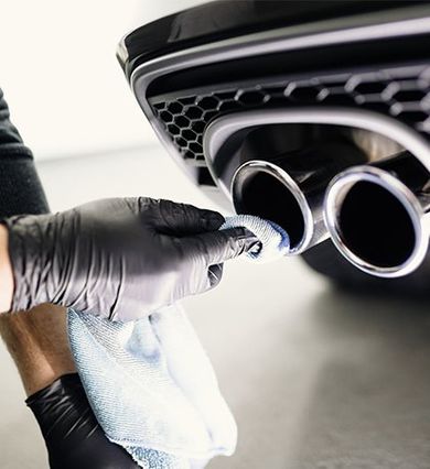 Man Cleaning Car Exhaust with Microfiber Cloth — New Britain, CT — The Transmission Works