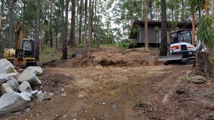 White and Yellow Excavator in the Woods — Earthmoving Services  in Eungai Creek, NSW