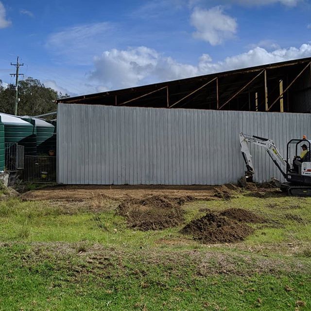 White Excavator Beside Barn — Earthmoving Services  in Eungai Creek, NSW